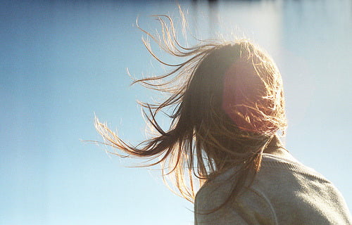 mulher com cabelo levantado pelo vento