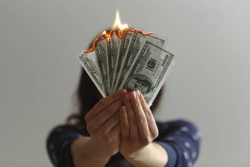 Viajante queimando dólar