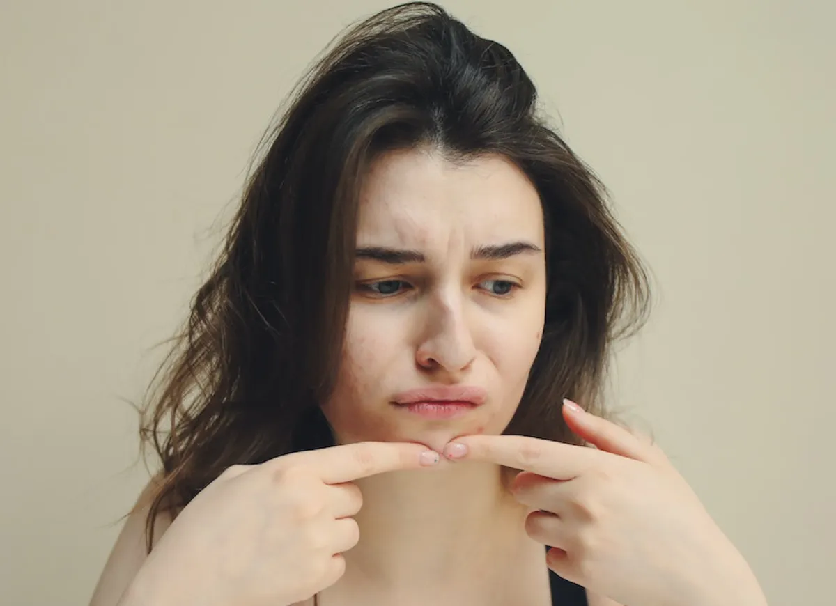 mulher olhando as manchas no rosto